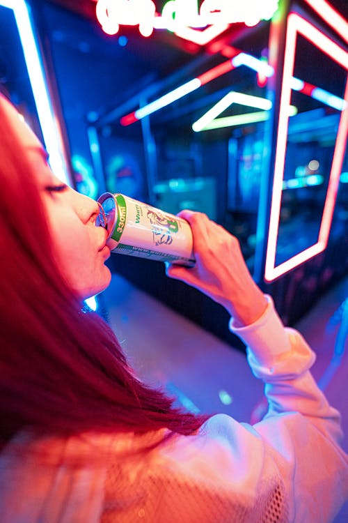 A Young Woman Drinking Soda from a Can