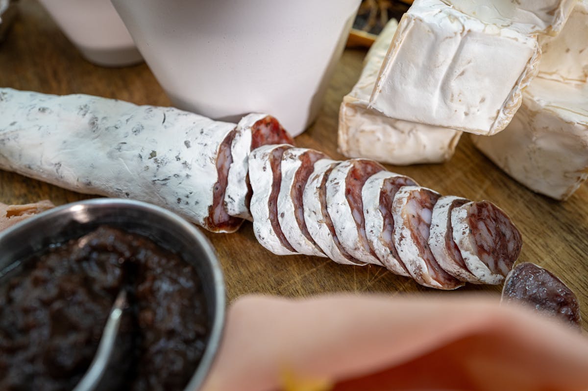 Fette di salame e formaggio disposte in primo piano su un tagliere