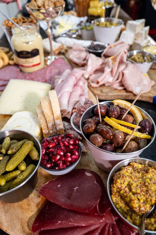 Antipasto board with meats, cheeses, olives, and condiments