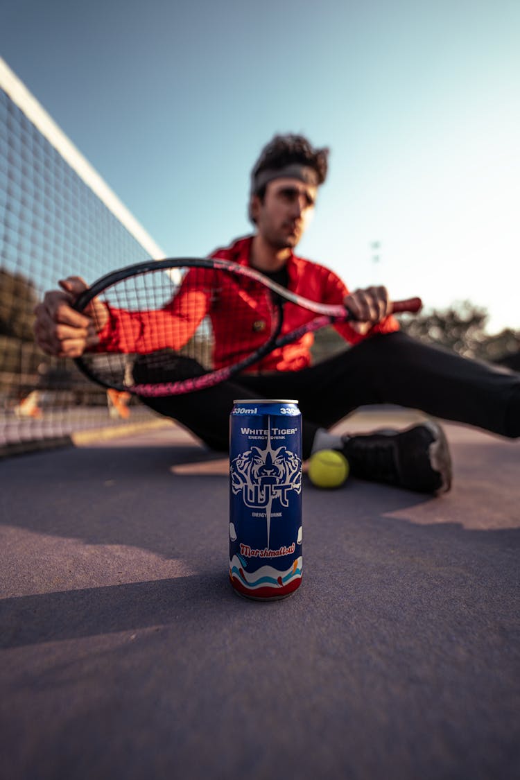 Tennis Player With Can Of Energy Drink On Court