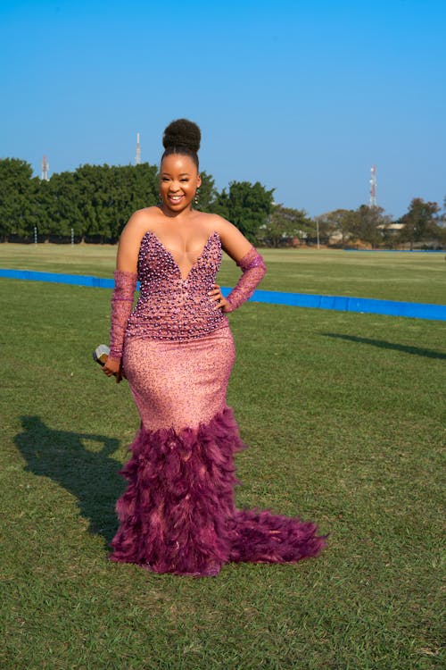 African Woman Wearing Pink Dress on a Field 