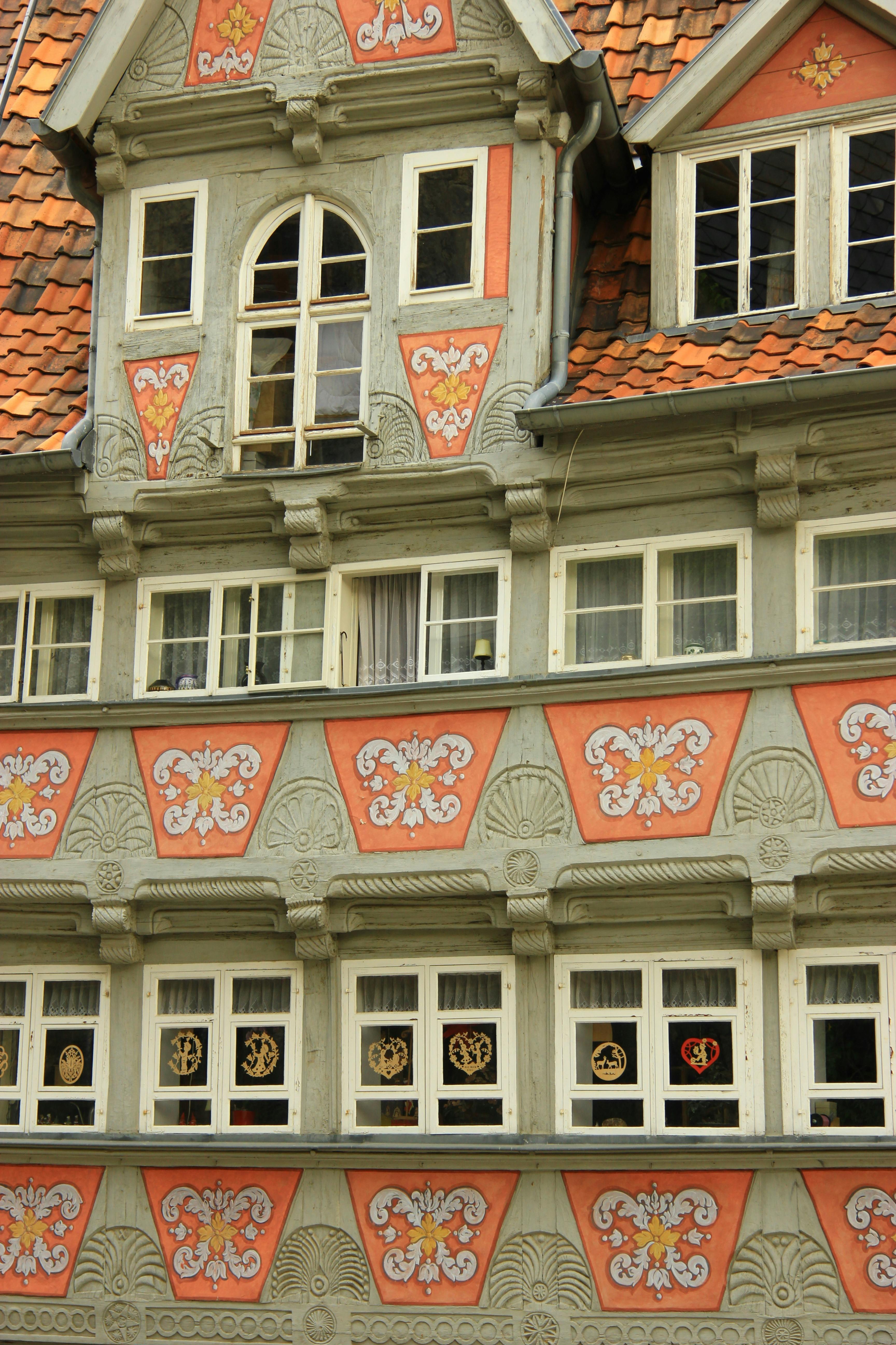 A beautifully ornate medieval building facade with decorative windows and wooden details.