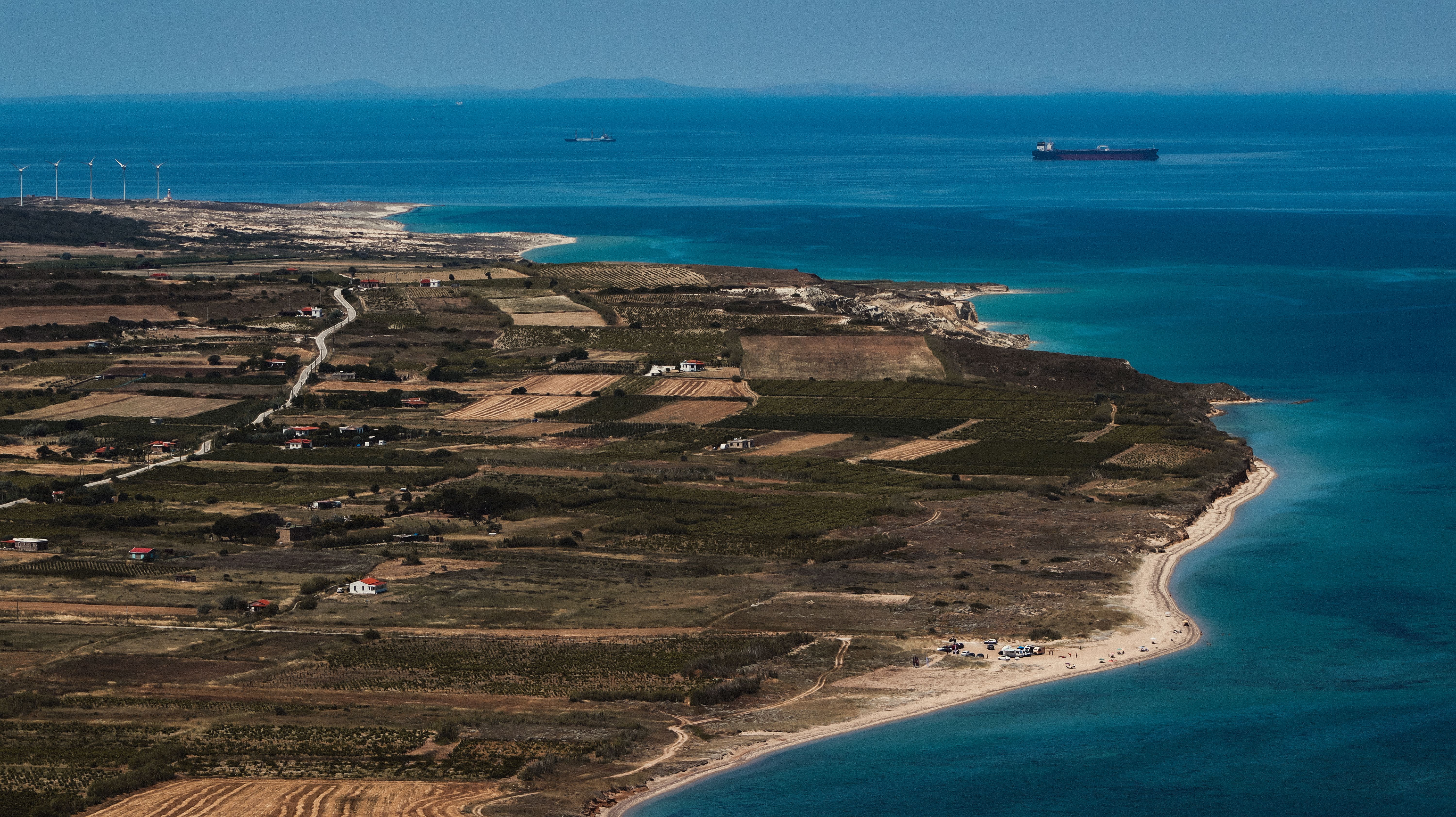 Stunning aerial shot of Bozcaada's coastline featuring farmland, beaches, and the Aegean Sea in Türkiye.