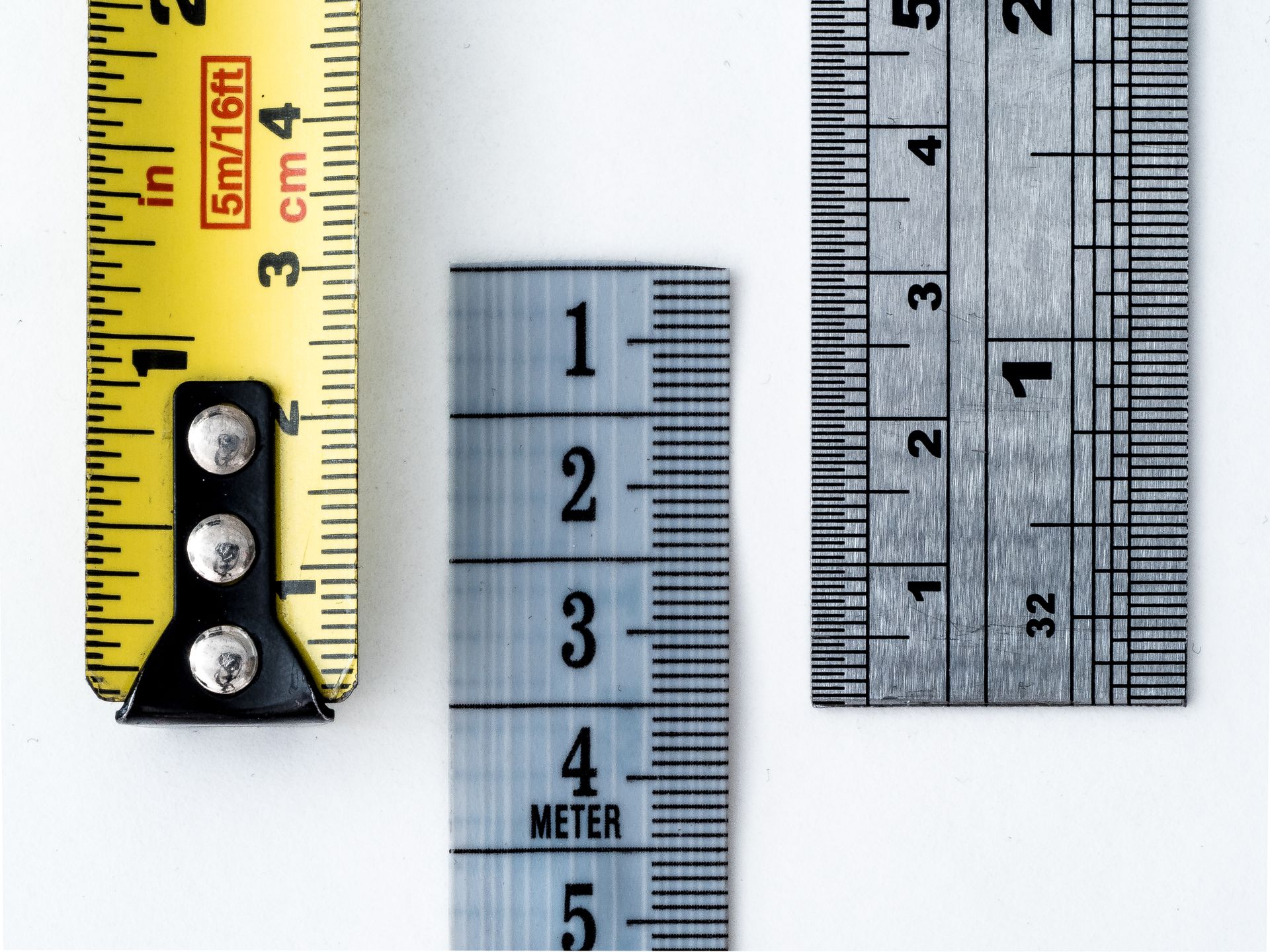 High-resolution image of a tape measure and rulers, showing precise millimeter, centimeter, and inch markings.