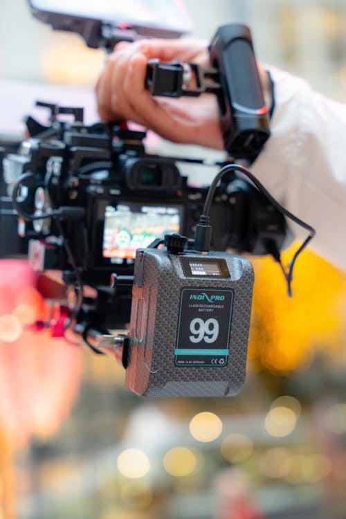 Close-up of a Person Holding a Professional Camera 