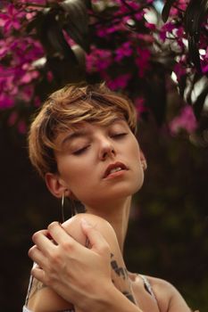 A peaceful portrait of a woman surrounded by vibrant flowers, exuding beauty and tranquility.