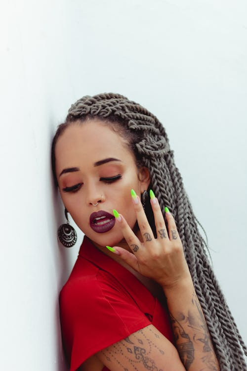 Femme Aux Cheveux Tressés S'appuyant Sur Le Mur