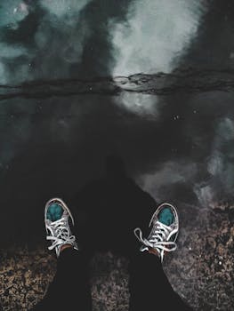 雨后，运动鞋在水坑中的倒影，展现出城市氛围