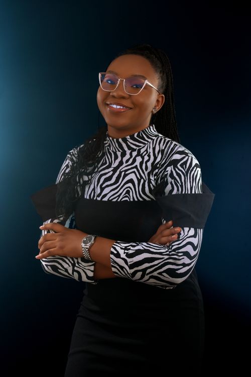 Free Elegant woman in zebra print top and eyeglasses posing confidently in a studio setting. Stock Photo