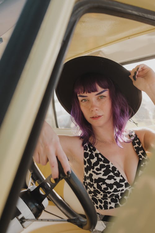Model with Purple Hair Posing in Hat in Truck
