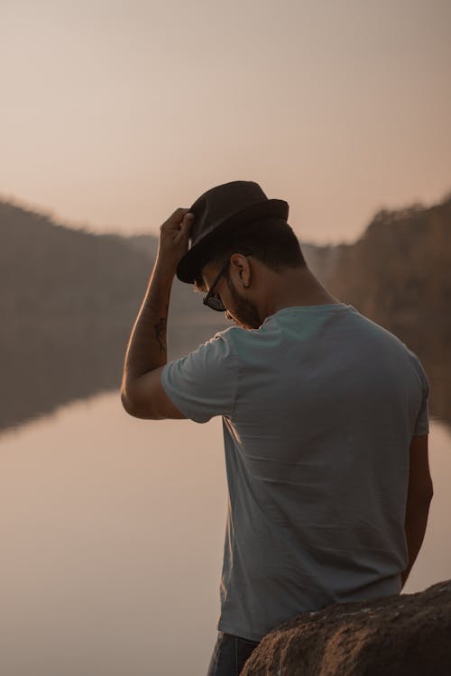 Man in Fedora by the Lake at Dusk