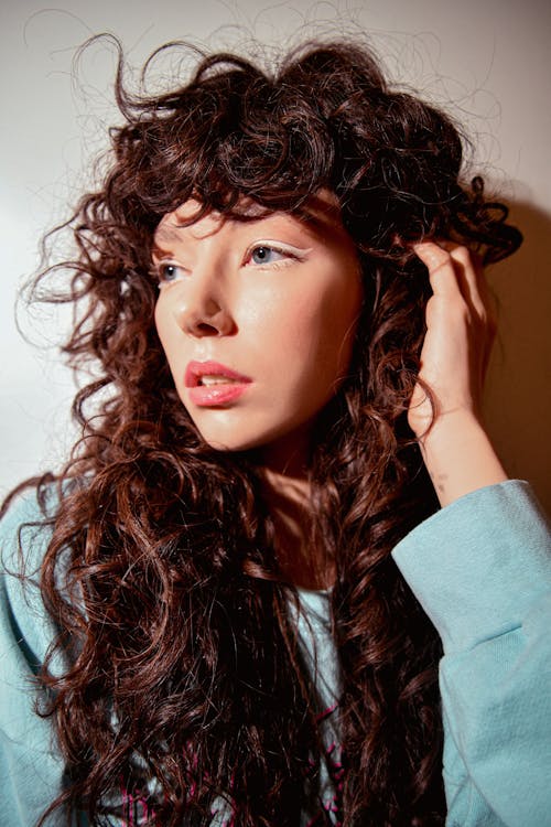Young Woman with Curly Hair Wearing a Blue Blouse 