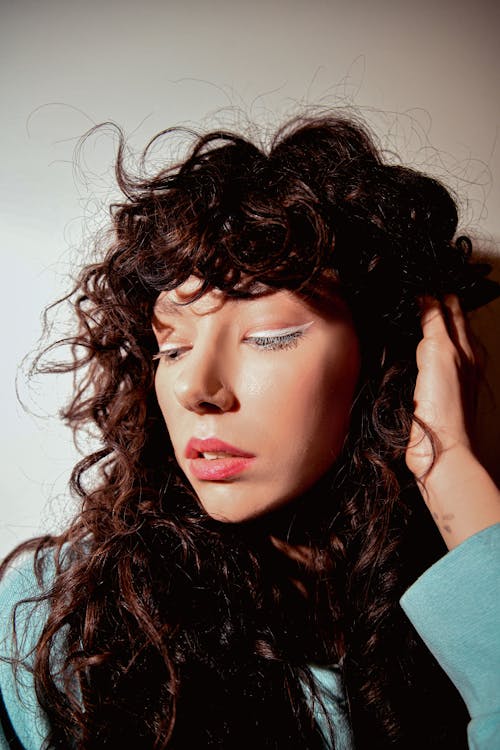 Studio Shot of a Young Woman with Curly Hair Wearing White Eyeliner 