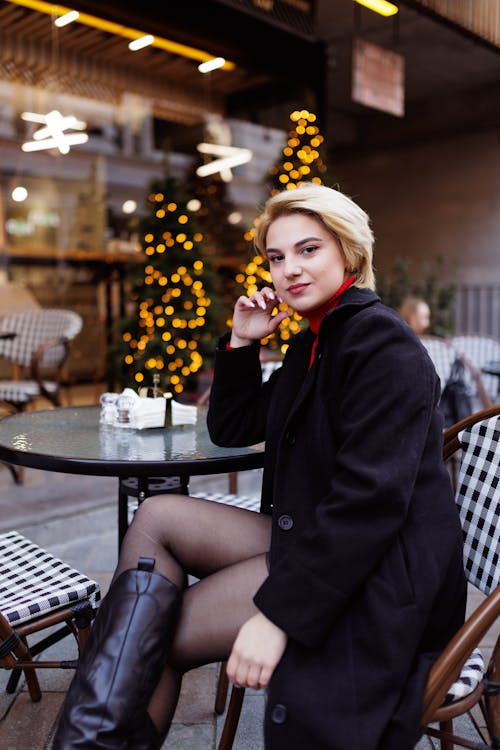 Free A woman sitting at a table talking on a cell phone Stock Photo
