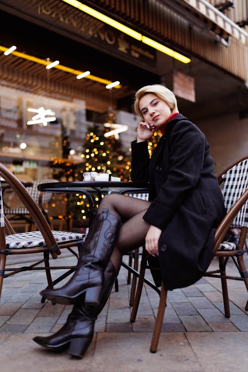 Free A woman sitting on a chair in front of a restaurant Stock Photo
