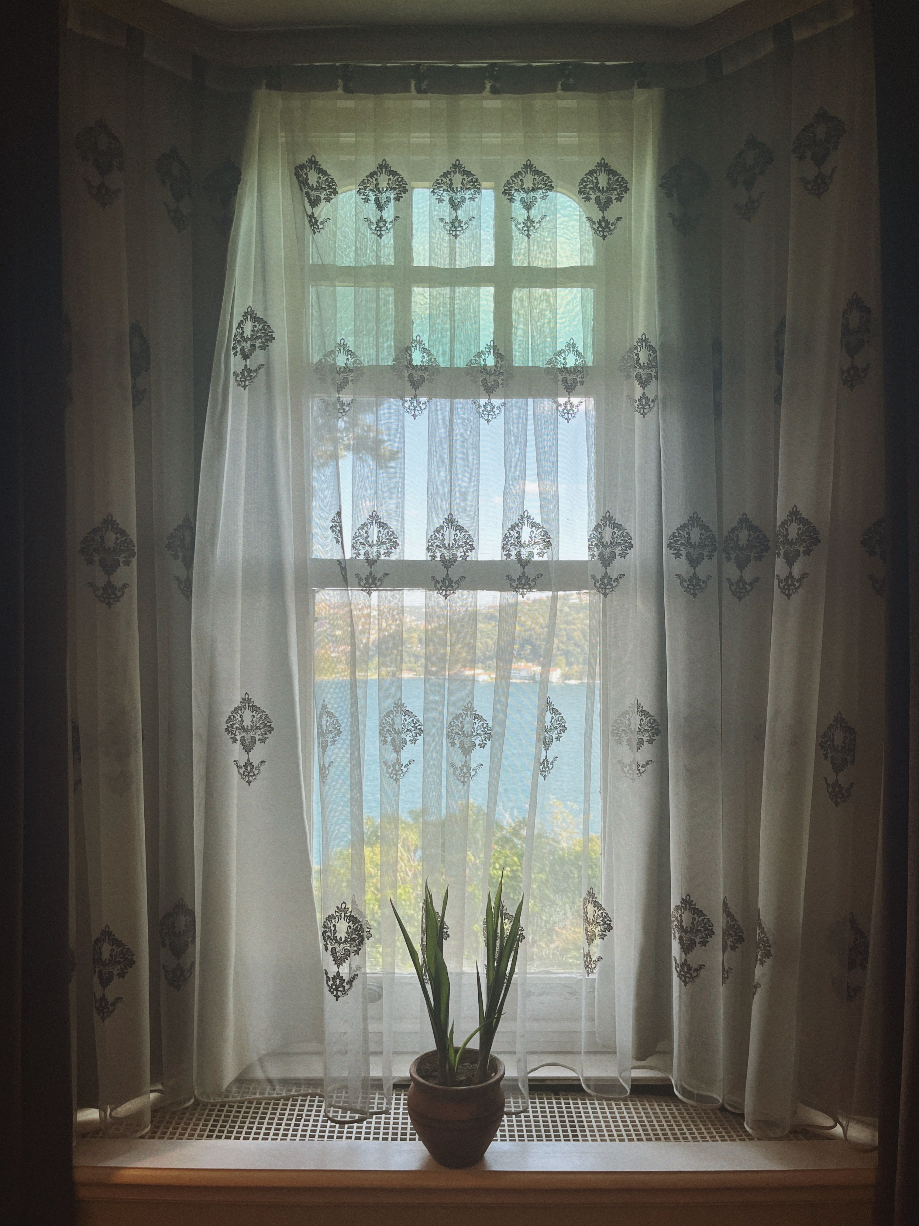 Free Delicate lace curtains reveal a peaceful view of the Bosphorus from an Istanbul windowsill. Stock Photo