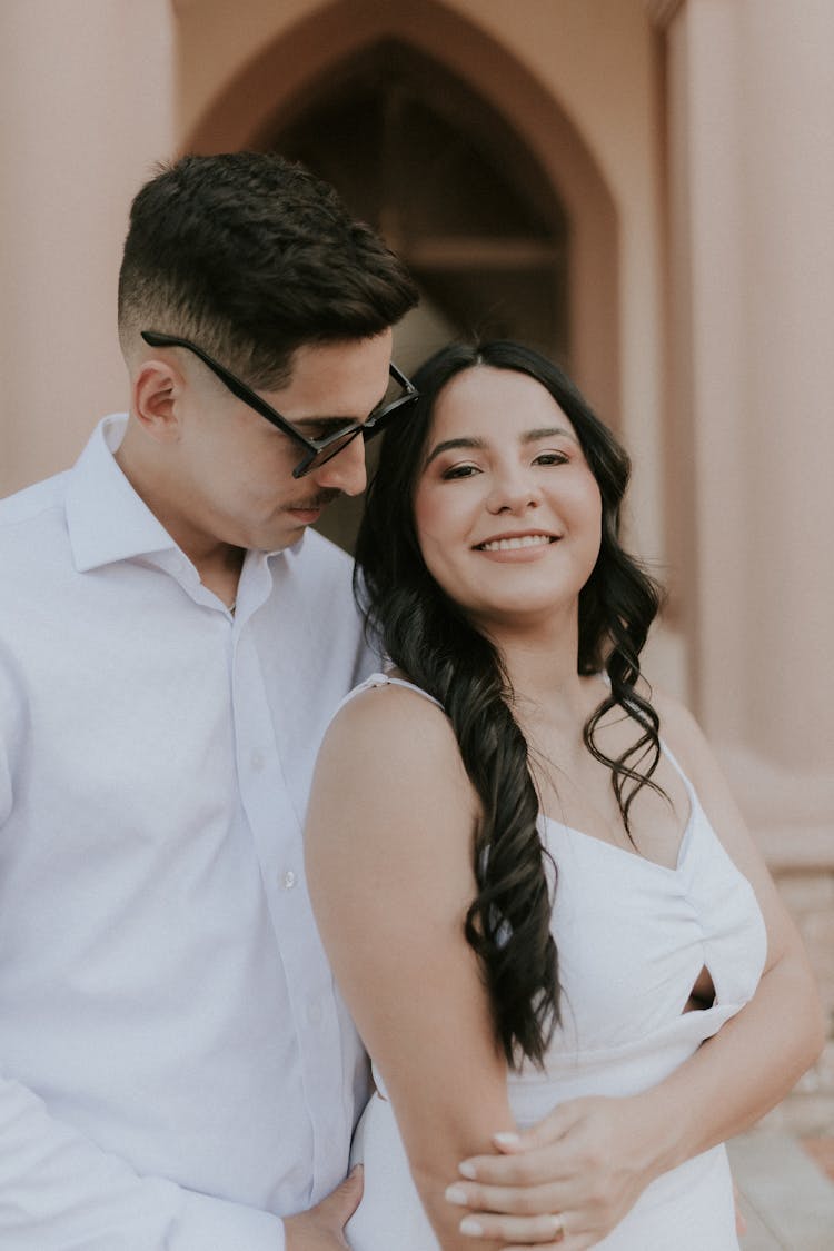 A Couple Standing Outside And Smiling 