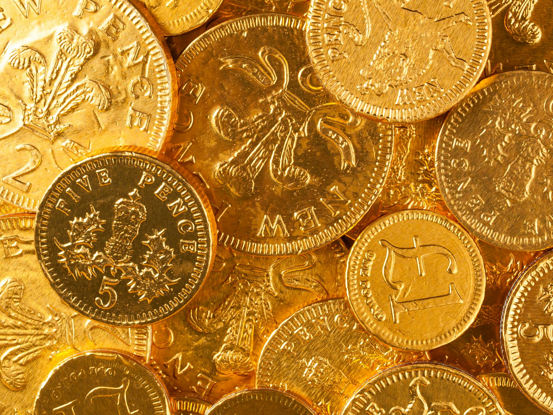 Detailed close-up of British pence coins with intricate designs, highlighting wealth and currency.