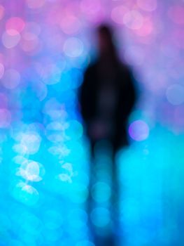 Abstract silhouette with vibrant blue and purple bokeh lights creating a dreamy effect.
