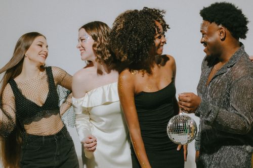 Free A diverse group of friends having fun at an indoor party with a disco ball. Stock Photo