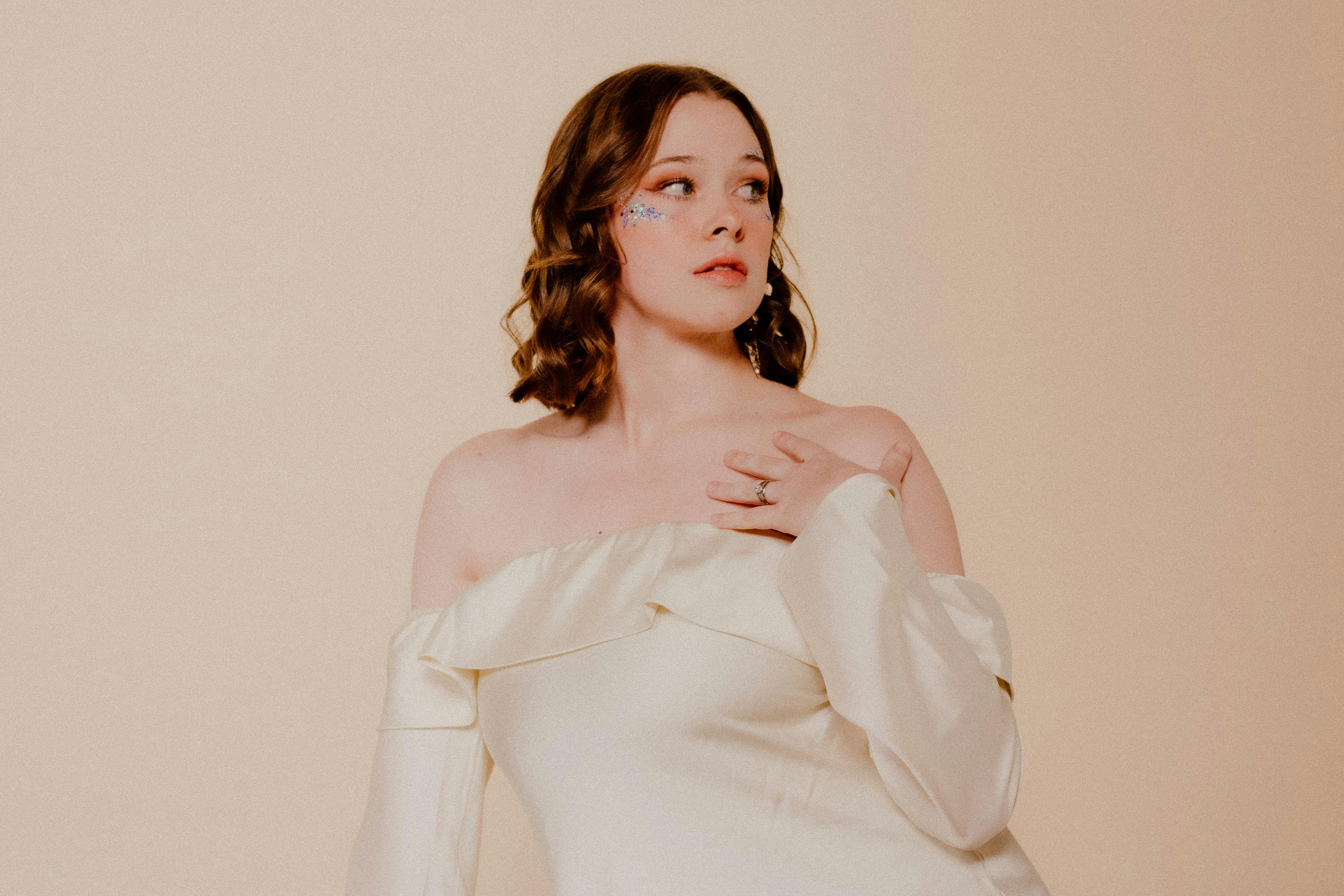 Stunning fashion portrait of a woman in a cream satin dress, exuding elegance and style.