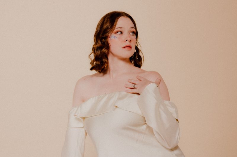 Woman in a cream satin midi dress