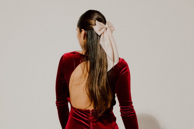 Woman In Glamour Dress With Bow On Hair Posing In Studio