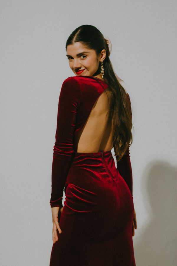 Woman posing in burgundy velvet dress