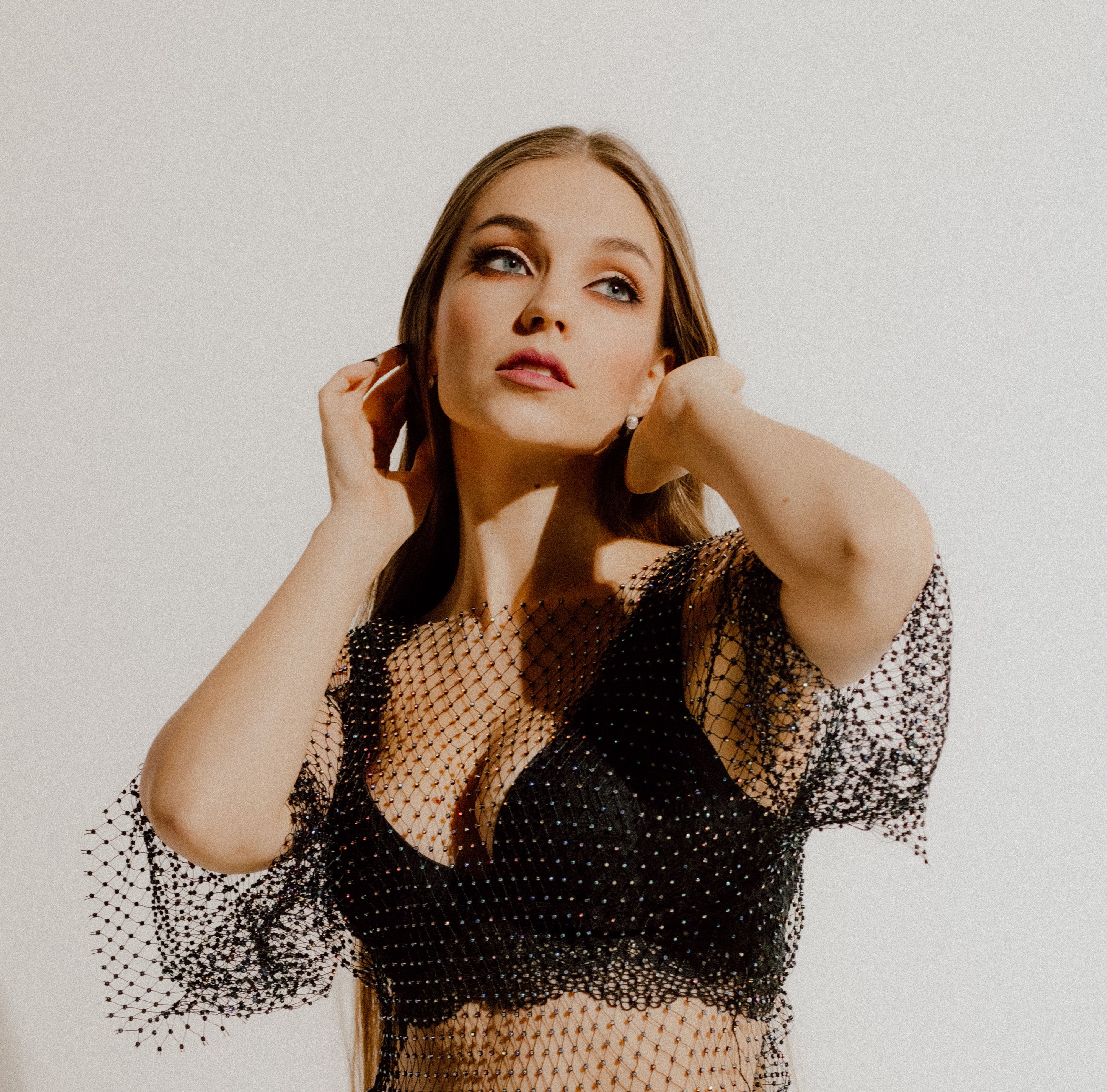 Stylish portrait of a woman posing in fashion lingerie with artistic lighting.