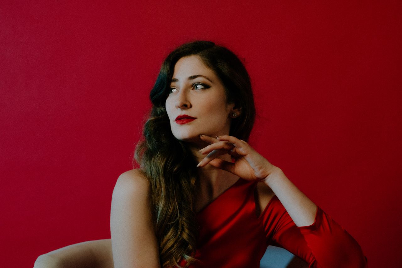 stunning portrait of a woman in red embodying elegance against a vibra
