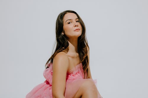 Young Brunette in Pink Dress Posing in Studio