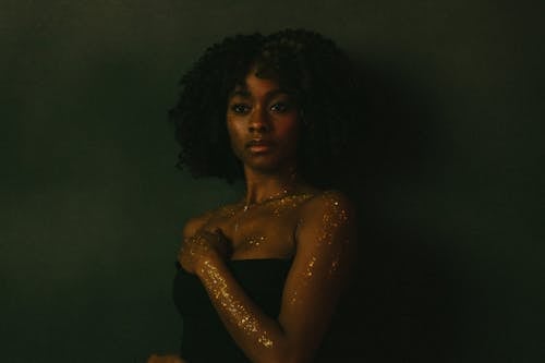 Young Black Woman with Glitter on Body Posing in Studio
