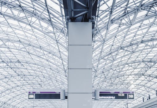 Captivating view of a modern station interior with intricate steel architecture and signage.