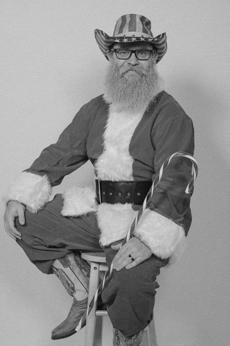 Senior Bearded Man In Santa Costume And Cowboy Hat