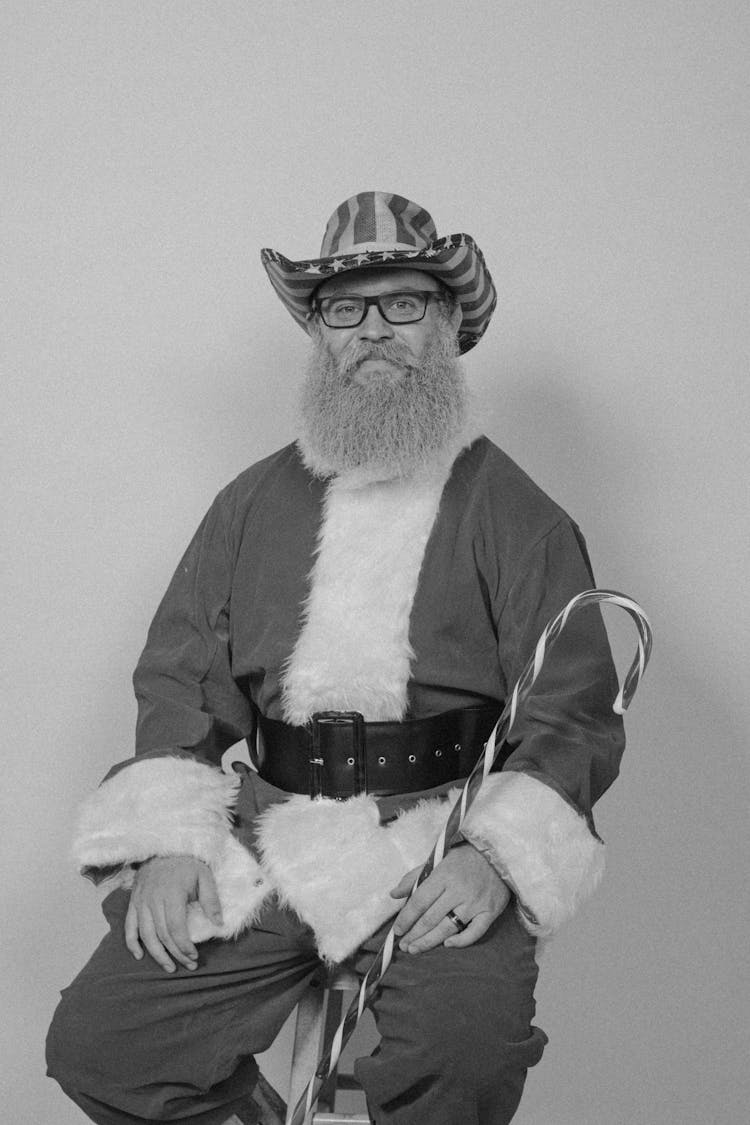 Senior Bearded Man In Santa Costume And Cowboy Hat