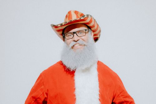 Free A humorous portrait of Santa Claus wearing a cowboy hat and glasses on a white background. Stock Photo