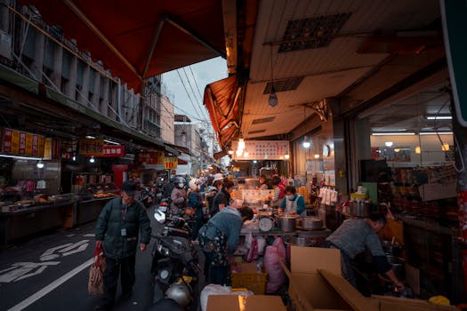 Lively market vendors and shoppers fill an outdoor street market in New Taipei City, Taiwan.