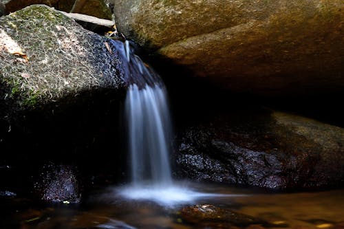 Small Cascade of Water from Mossy Boulders