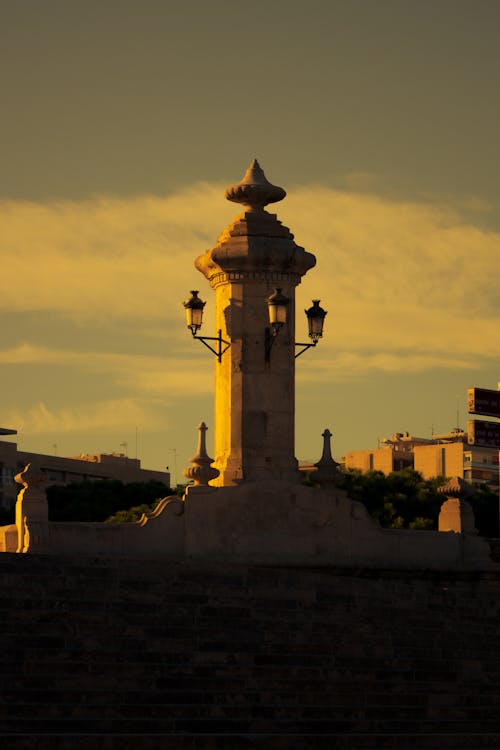 Silhouetted Tower with Antique Lanterns at Sunset