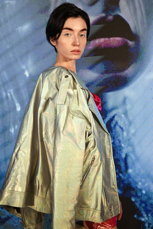 Young Woman Wearing a Shiny Jacket and Posing in Studio 