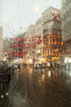 View of a rainy street in Istanbul seen through a tram window capturing urban life.