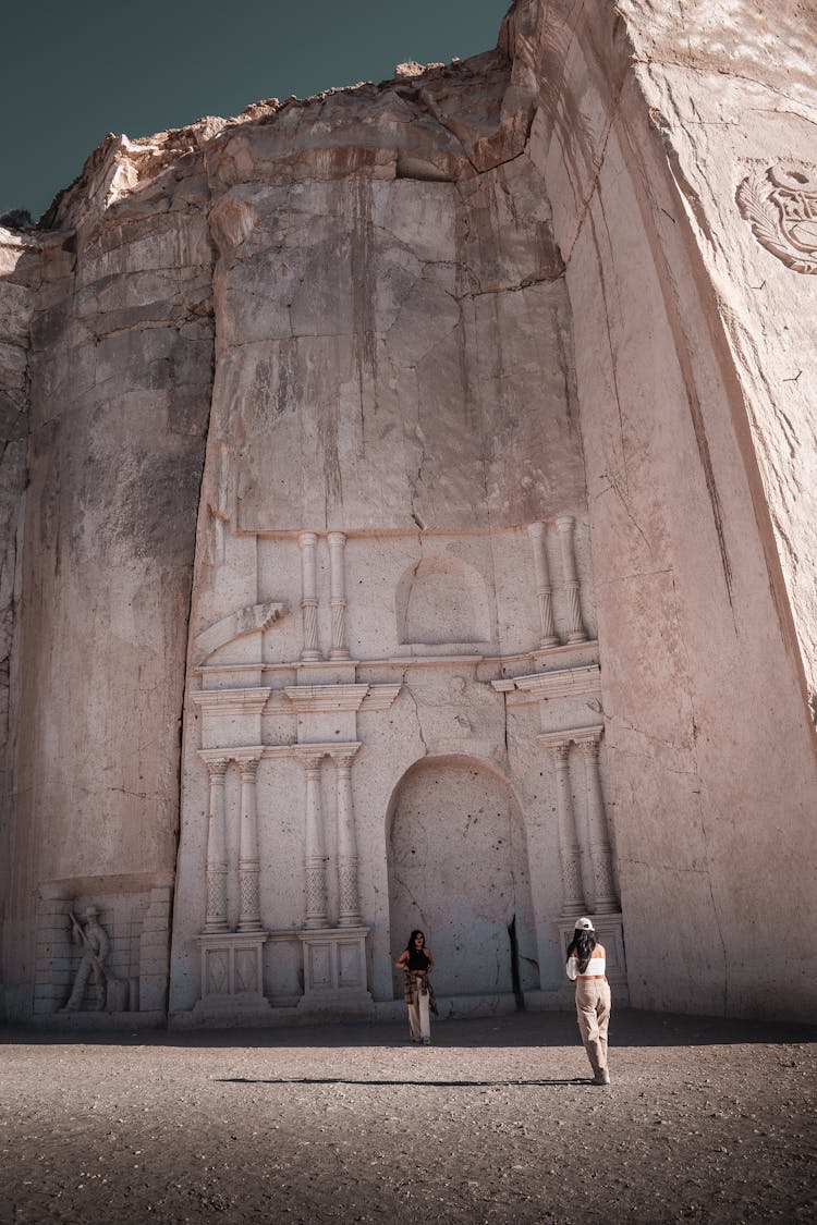 Tourists Taking Photos Under The Carved Rock Wall At The Ruta Del Sillar