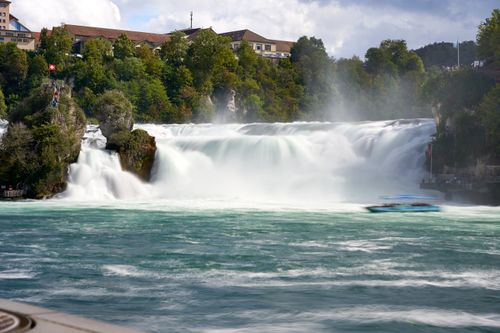 Free A breathtaking sight of the powerful Rhine Falls in Switzerland, surrounded by lush greenery. Stock Photo