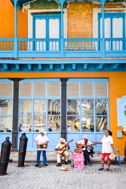 Free Street musicians playing in front of a colorful building in Havana, Cuba. Stock Photo