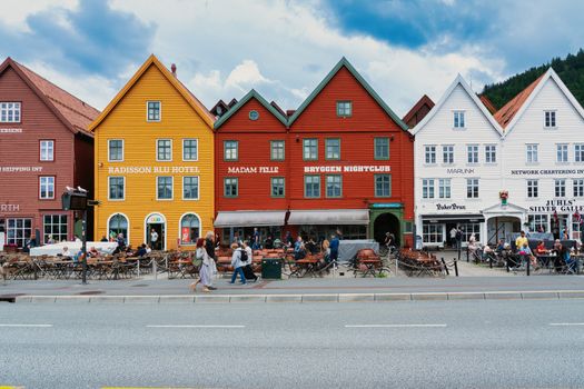 Vibrant historical buildings line the streets of Bergen, Norway, showcasing charming cafes and shops.