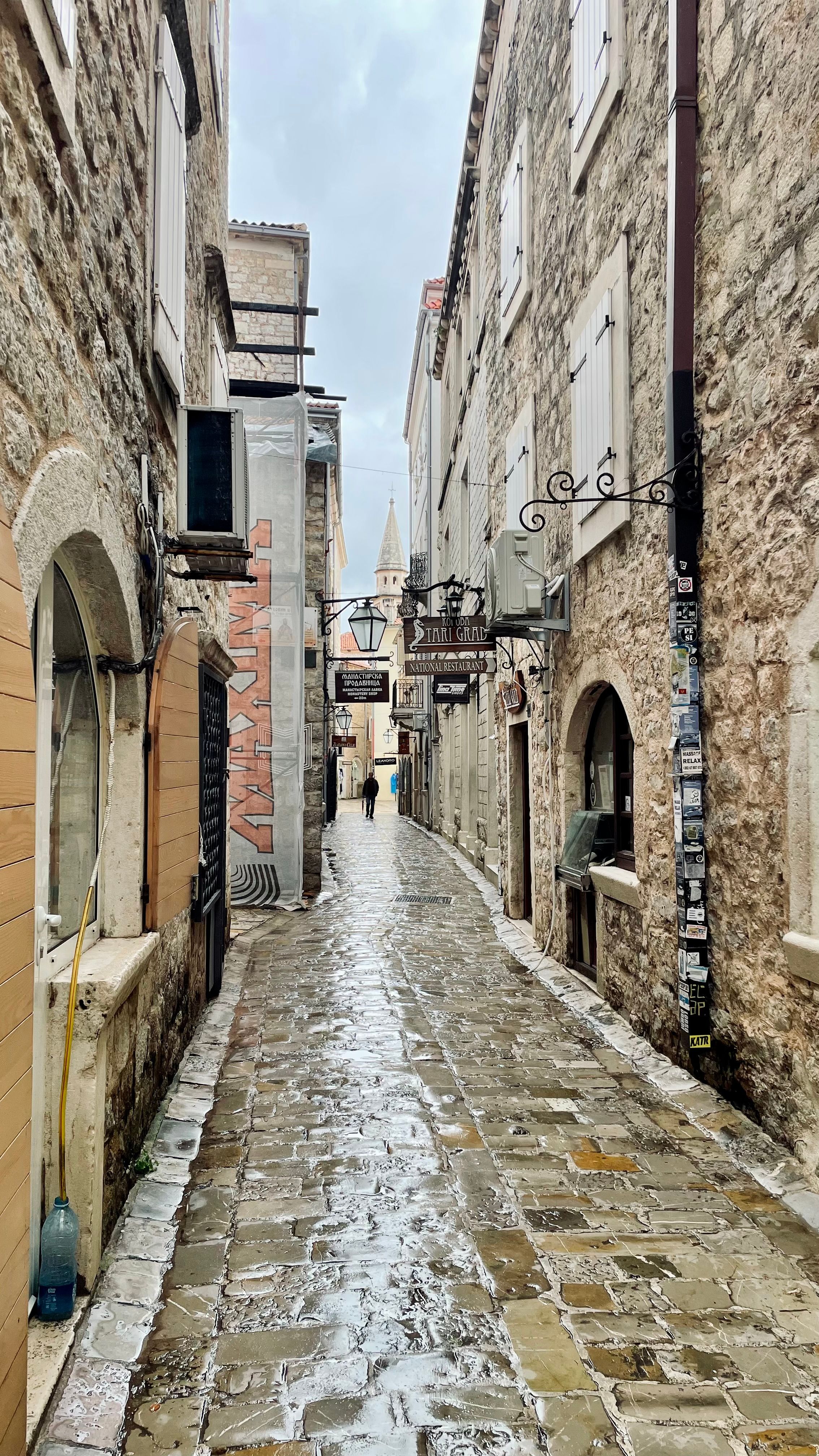 Ruelle pavée bordée de bâtiments en pierre, trop étroite pour un véhicule utilitaire.