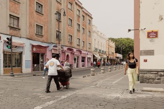 Busy urban street scene with pedestrians in Heroica Puebla de Zaragoza, Mexico.