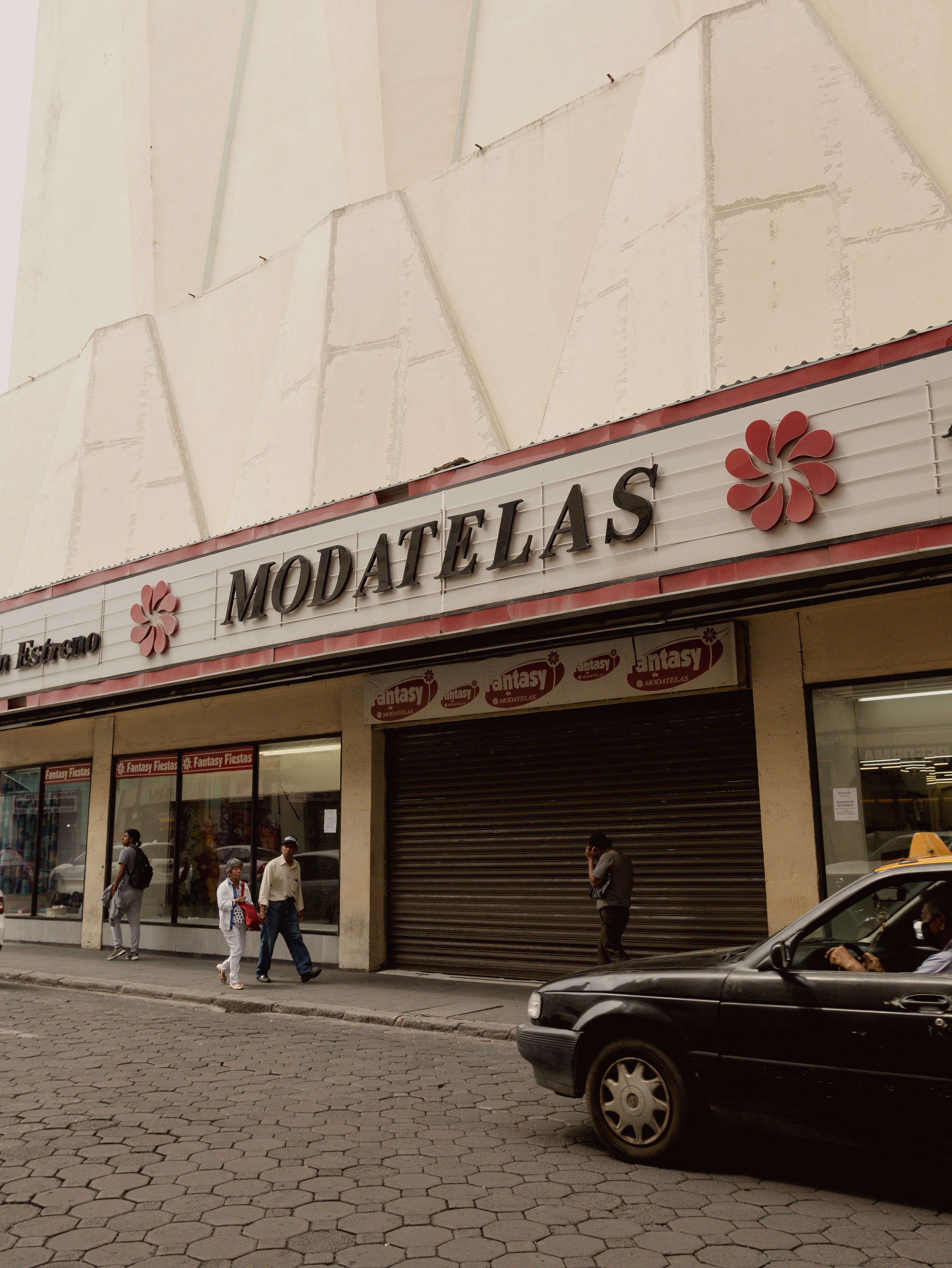 Urban scene in Puebla, Mexico showcasing a storefront and pedestrians on a city street.