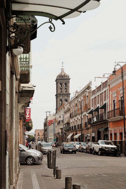Free Charming street in Puebla, Mexico with colonial architecture and a prominent church tower. Stock Photo