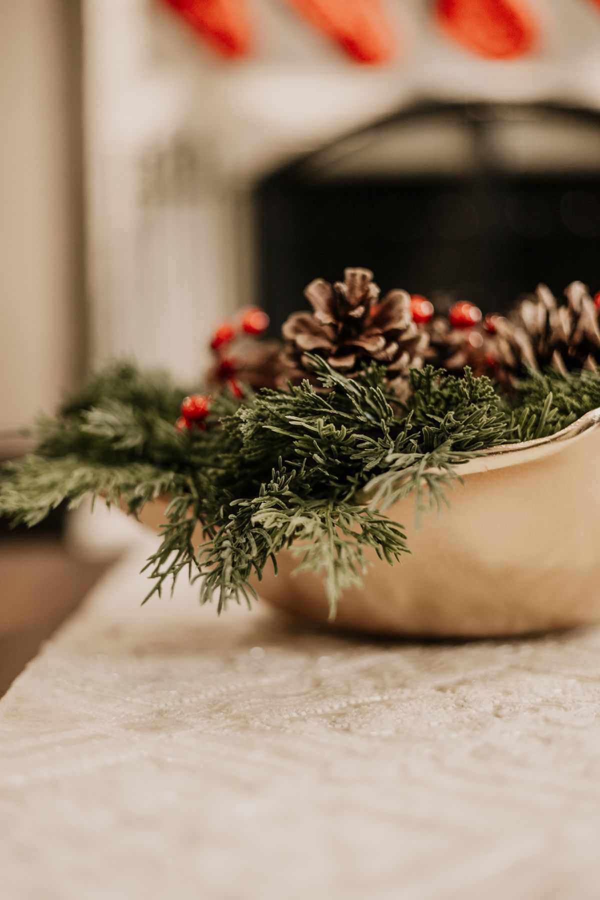 Cozy Christmas centerpiece with evergreen branches and pine cones in a bowl